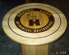 round Maple contractors table with a inlaid Corp. logo